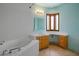 Bright bathroom with wooden cabinets, tile flooring and a tile tub in a well-lit modern space at 3101 Margarita St, Pahrump, NV 89048