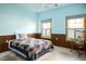 Cozy bedroom with blue and brown walls, two shuttered windows, and a queen-size bed with a colorful quilt at 3101 Margarita St, Pahrump, NV 89048