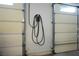 Garage with two doors and containing an electric car charger on the wall for easy charging at 3101 Margarita St, Pahrump, NV 89048
