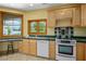 Kitchen showcasing wooden cabinets, tile countertops, and natural light from multiple windows at 3101 Margarita St, Pahrump, NV 89048