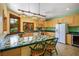 Bright kitchen featuring tile counters, wood cabinets, and a charming breakfast bar with seating at 3101 Margarita St, Pahrump, NV 89048
