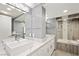 Bright bathroom with double sinks, sleek white cabinets, and a glass-enclosed shower and tub combination at 3111 Bel Air Dr # 3C, Las Vegas, NV 89109