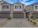 Charming townhome with brown shutters, a two-car garage, and a paved driveway with desert landscaping at 3795 Canis Minor Ln # 5102, Henderson, NV 89052