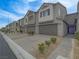 Attractive townhome row with two-car garages, desert landscaping, and a paved driveway at 3795 Canis Minor Ln # 5102, Henderson, NV 89052