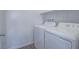 Laundry room with full size white washer and dryer and wood-look flooring at 3795 Canis Minor Ln # 5102, Henderson, NV 89052