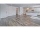 Bright, open-concept living area with wood-look flooring, white walls, and a modern kitchen in the background at 3795 Canis Minor Ln # 5102, Henderson, NV 89052