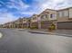 Street view of townhomes with garages and desert landscaping in front at 3795 Canis Minor Ln # 5102, Henderson, NV 89052
