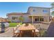 Staged backyard with outdoor dining set, grill, artificial turf and desert landscaping at 4001 Turquoise Falls St, Las Vegas, NV 89129