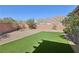 Backyard featuring artificial turf, desert landscaping, and a block wall for privacy at 4001 Turquoise Falls St, Las Vegas, NV 89129
