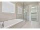 Bright bathroom featuring a soaking tub and glass-enclosed shower at 4001 Turquoise Falls St, Las Vegas, NV 89129