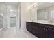 Modern bathroom featuring dual sinks, dark cabinets, and a glass-enclosed shower at 4001 Turquoise Falls St, Las Vegas, NV 89129