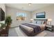 Staged bedroom featuring large window, king bed, and matching end tables with lamps at 4001 Turquoise Falls St, Las Vegas, NV 89129