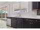 Close-up showcasing kitchen sink, light countertops, and dark cabinets with outdoor view from window at 4001 Turquoise Falls St, Las Vegas, NV 89129