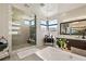 Bright bathroom with a walk-in shower, soaking tub, dual sink vanity, and mountain views at 4208 Lapis Ridge Ct, Las Vegas, NV 89135