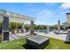 Inviting outdoor kitchen and pool area with a built-in grill, fire pit, and lush landscaping at 4208 Lapis Ridge Ct, Las Vegas, NV 89135