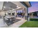 Inviting covered patio with elegant dining, lounge areas, ceiling fans, and seamless transition to a lush landscaped backyard at 4208 Lapis Ridge Ct, Las Vegas, NV 89135