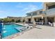 Luxurious backyard featuring a sparkling pool, sun loungers, and an outdoor living area for entertaining at 4208 Lapis Ridge Ct, Las Vegas, NV 89135