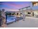 Backyard pool at dusk with patio and lounging furniture, illuminated by landscape and architectural lighting at 4208 Lapis Ridge Ct, Las Vegas, NV 89135
