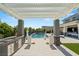 A luxurious pool area with a covered outdoor kitchen and a view of the sparkling pool at 4208 Lapis Ridge Ct, Las Vegas, NV 89135