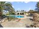 A backyard boasting a pool, covered patio, mature trees, and landscaping offers a private space for relaxation at 4343 Sharpshooter Ln, North Las Vegas, NV 89031
