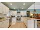 Bright kitchen featuring white cabinets, stainless steel appliances, and an eat-in island that's open to the living space at 4343 Sharpshooter Ln, North Las Vegas, NV 89031
