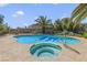 Sparkling in-ground pool with jacuzzi, concrete patio, and tropical palm trees creates a backyard oasis for relaxation at 4343 Sharpshooter Ln, North Las Vegas, NV 89031