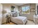 Neutral bedroom with patterned bedding, decorative pillows, side tables with lamps, and a window with natural light at 4420 Stardusk Falls Ave, North Las Vegas, NV 89084