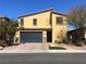 Two-story home featuring a two-car garage, desert landscaping, and a yellow exterior against a clear blue sky at 4420 Stardusk Falls Ave, North Las Vegas, NV 89084
