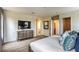 Bright main bedroom showcasing a king bed, TV, and ensuite bathroom, all adorned with soft, neutral tones at 4420 Stardusk Falls Ave, North Las Vegas, NV 89084