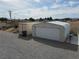 Functional backyard with storage container, garage, and seating area, creating a practical and adaptable outdoor space at 4861 Pahrump Valley Blvd, Pahrump, NV 89048