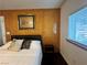 Comfortable bedroom with wood paneling and a bright window with blinds at 4861 Pahrump Valley Blvd, Pahrump, NV 89048