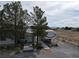 Street view of single story home, long driveway, desert landscaping and mature trees at 4861 Pahrump Valley Blvd, Pahrump, NV 89048