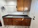 Functional laundry area featuring wooden cabinets, a gray countertop, sink, and hanging rack for organized convenience at 4861 Pahrump Valley Blvd, Pahrump, NV 89048