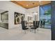 Modern dining room with glass table, wine display, and large windows providing backyard view at 49 Crested Cloud Way, Las Vegas, NV 89135