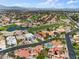 Scenic aerial view of a community showcasing lush landscaping and a nearby golf course with a tranquil pond and mountain views at 5205 Sandy Cactus Ln, Las Vegas, NV 89149