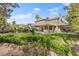 Large backyard featuring lush grass, a covered patio, mature trees, and tasteful landscaping for outdoor enjoyment at 5205 Sandy Cactus Ln, Las Vegas, NV 89149
