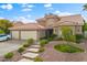 Elegant two-story home featuring a terracotta roof, concrete steps, a three-car garage, and landscaped front yard at 5205 Sandy Cactus Ln, Las Vegas, NV 89149