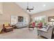 Comfortable living room featuring neutral walls, carpet floors, large windows, and a vaulted ceiling with a ceiling fan at 5205 Sandy Cactus Ln, Las Vegas, NV 89149