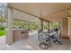 Covered outdoor dining area with a built-in grill and landscaped backyard at 5205 Sandy Cactus Ln, Las Vegas, NV 89149