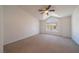 This naturally lit bedroom features neutral carpet and a large arched window at 5256 Harvest Breeze Rd, Las Vegas, NV 89118
