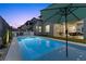 Inviting backyard pool with a sun umbrella, complemented by lush landscaping and comfortable seating areas at 532 Crown Mesa Ave, Las Vegas, NV 89138