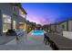 Backyard featuring an outdoor kitchen and BBQ grill, adjacent to a pool with a dining table set at 532 Crown Mesa Ave, Las Vegas, NV 89138