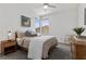 Bright bedroom featuring neutral tones, a ceiling fan, a large window, and stylish decor at 532 Crown Mesa Ave, Las Vegas, NV 89138