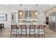 Bright kitchen with island seating, stainless steel appliances, and modern pendant lighting create an inviting cooking space at 532 Crown Mesa Ave, Las Vegas, NV 89138