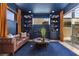 Stylish office with a leather sofa, custom bookshelves, and a view to the outdoors creating the perfect workspace at 532 Crown Mesa Ave, Las Vegas, NV 89138
