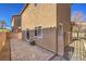 A view of the stucco home in the background with a paved patio and brick wall at 6217 Red Jamboree Ct, Las Vegas, NV 89130
