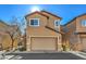 Two-story tan home with a two car garage and simple landscaping on a sunny day at 6217 Red Jamboree Ct, Las Vegas, NV 89130