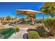 Community playground with shaded play structures and adjacent seating area at 6217 Red Jamboree Ct, Las Vegas, NV 89130