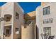 Modern condo building with a textured facade and private balconies under a bright blue sky at 6883 Tamarus St # 203, Las Vegas, NV 89119