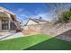 A private backyard with artificial turf, a concrete patio, and block wall fencing at 6982 Rusty Nail Way, Las Vegas, NV 89119